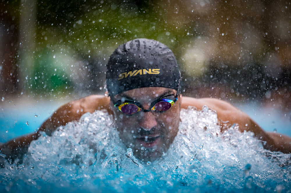 SWANS SRX Prescription Goggles with a double silicone strap and interchangeable nose piece. The goggles have mirror black and smoke orange lenses.