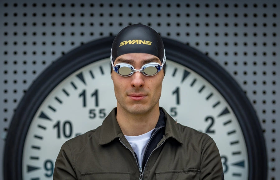 Swim goggles with blue lenses and white frame.